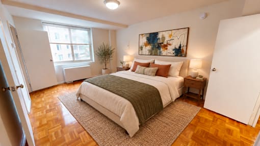 A bedroom with a large bed and a painting on the wall.