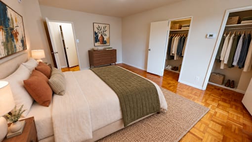 A bedroom with a large bed and a wooden dresser.