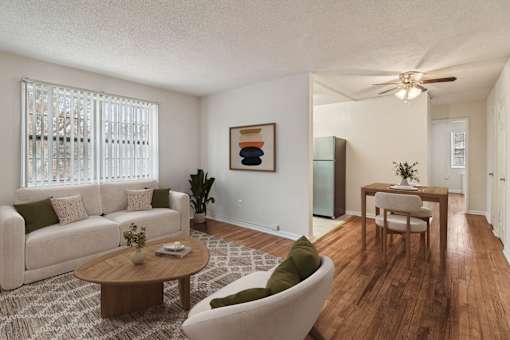 A living room with a white couch, a wooden coffee table, and a painting on the wall.