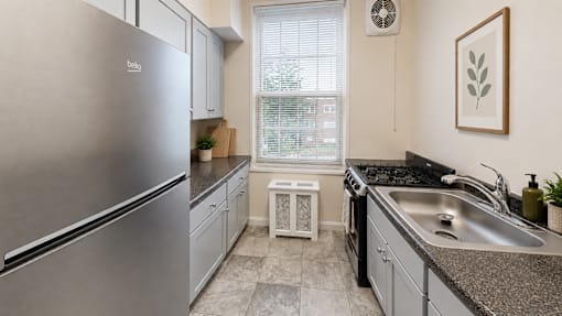 A modern kitchen with a stainless steel refrigerator and a granite countertop.