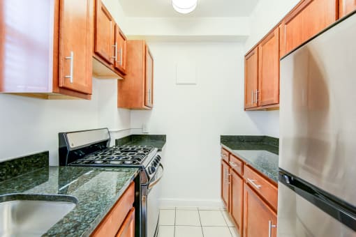 Renovated kitchen with stainless steel appliances and oak cabinetry at 2800 woodley road apartments in woodley park washington dc