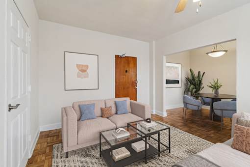 A living room with a couch, a coffee table, and a plant.