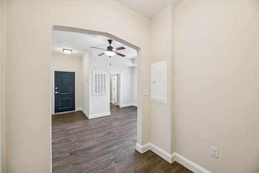 A room with a ceiling fan and a door.