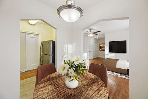 A dining room with a wooden table and chairs.