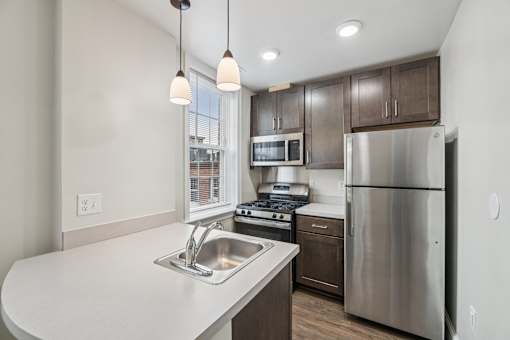 A modern kitchen with stainless steel appliances and wooden cabinets.