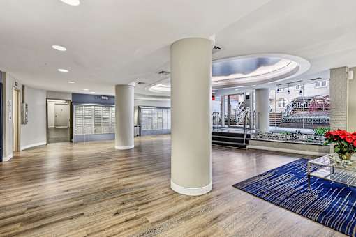 A large room with a wooden floor and a long white column.