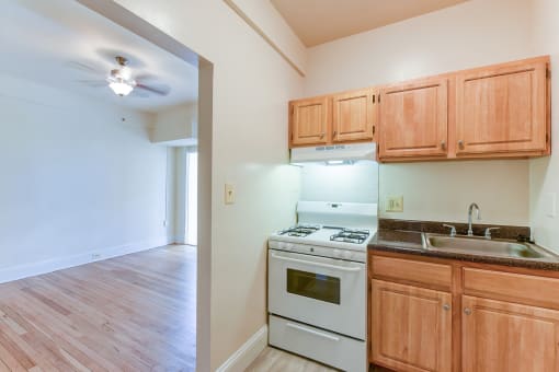 kitchen with wood cabinetry, gas range and view of living area  at twin oaks apartments columbia heights washington dc