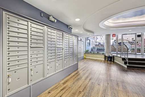 A long hallway with mailboxes on the wall and a staircase on the right.