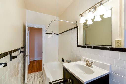 bathroom with tub, vanity, large mirror and tile details at  2701 Connecticut apartments in washington dc