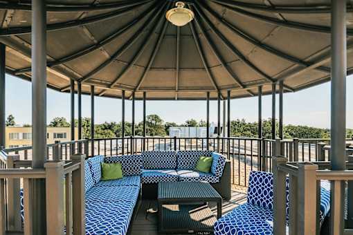 A patio with a blue couch and a black table.