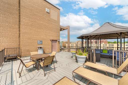 A patio with a table and chairs is surrounded by a brick building.
