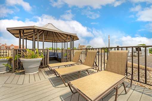 A wooden deck with a canopy and chairs.