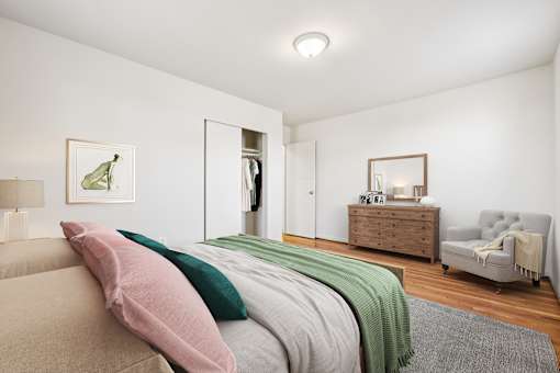 A bedroom with a bed, a dresser, a mirror, and a chair.