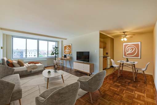 A living room with a grey couch, a white coffee table, and a brown rug.