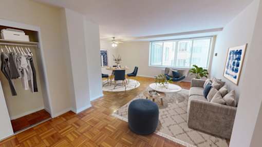 A well-lit, spacious living room with a wooden floor and a large window.