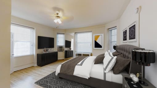 bedroom with bed, dresser, night stands, tv, ceiling fan and large windows at the calvertion apartments in washington dc