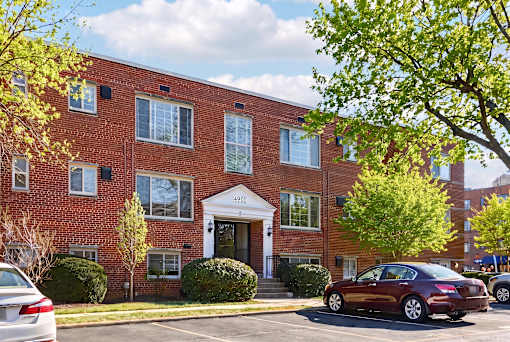 A red brick building with a white door and windows.