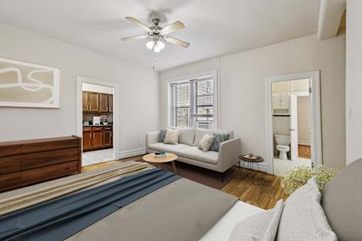 A living room with a couch, a coffee table, and a ceiling fan.