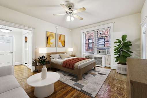 A bedroom with a bed, a couch, a table, and a ceiling fan.