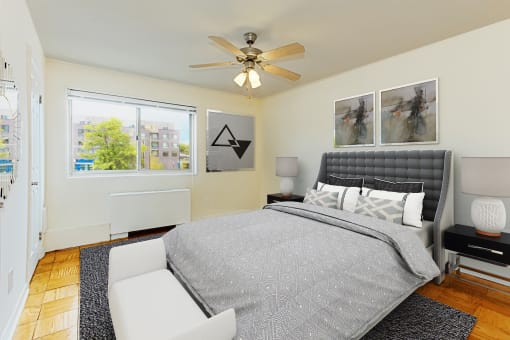 bedroom with wood flooring, bed, night stands, ceiling fan, and large windows at chillum place apartments in washington dc