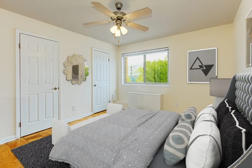 a bedroom with a bed, 2 closets, ceiling fan and window at chillum place apartments in washington dc