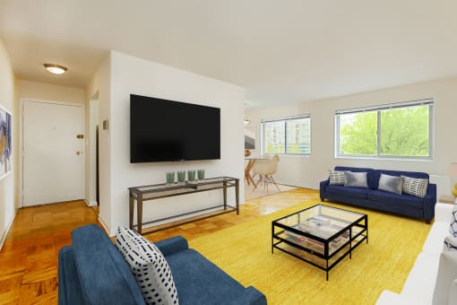 living area with wood flooring, sofa, love seat, coffee table, tv and large windows at chillum place apartments in washington dc