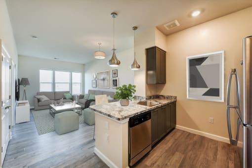 kitchen with stainless steel appliances, and view of living area with large windows at at city view apartments in washington dc