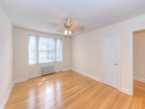 vacant bedroom with hardwood flooring and ceiling fan at 6100 14th Street apartments in washington dc