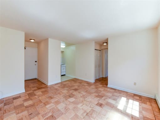 vacant living area with hardwood floors and view of entrance at alpha house apartments in washington dc