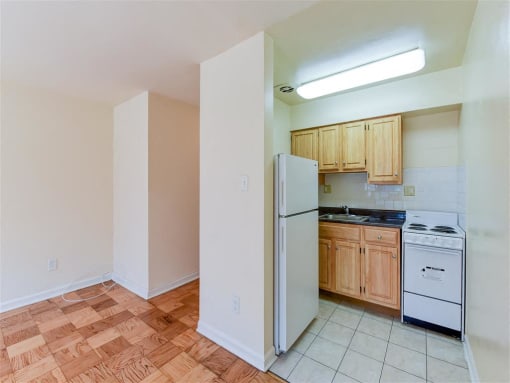 kitchen with tile floor, wood cabinetry, gas stove and energy efficient appliances at alpha house apartments in washington dc
