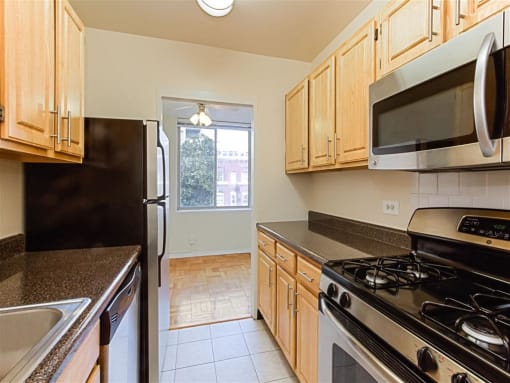 kitchen with stainless steel appliances, and view of dining area with hardwood floors at brunswick house apartments in dupont circle washington dc