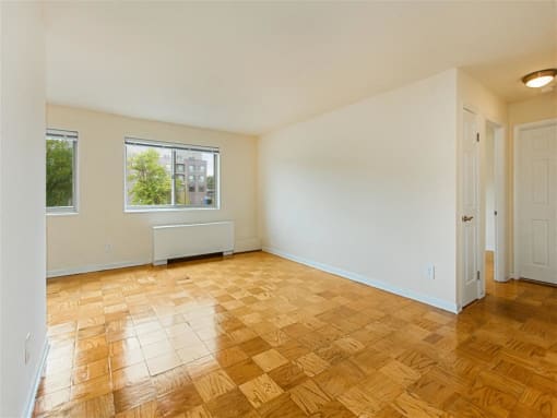 vacant living area with hardwood flooring and large windows at chillum place apartments in lamond riggs washington dc
