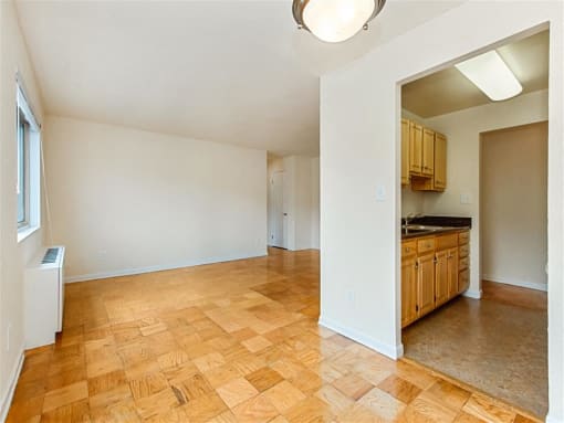 vacant dining area with view of living area with hardwood floors and large windows at chillum place apartments in lamond riggs washington dc