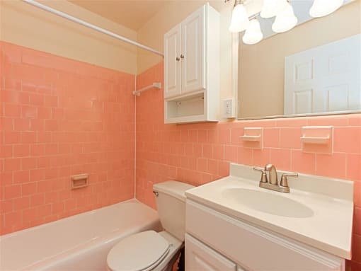 bathroom with sink, mirror, tub, toilet, medicine cabinet and tile detail at chillum place apartments in lamond riggs washington dc