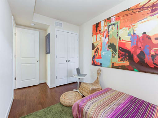 small bedroom with bed, dresser, desk and window at fairway park apartments in washington dc
