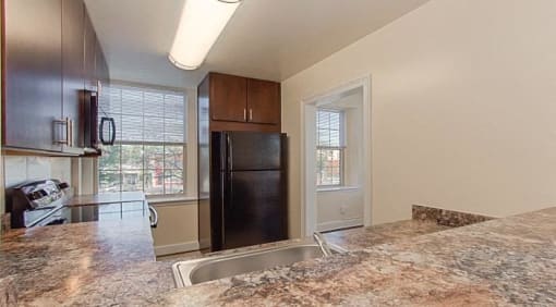 kitchen with espresso cabinetry, window, breakfast bar and energy efficient appliances at juniper courts apartments in takoma washington dc