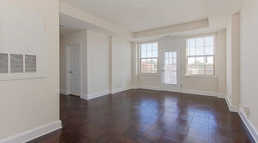 vacant living area with french door leading to balcony and large windows at juniper courts apartments in takoma washington dc