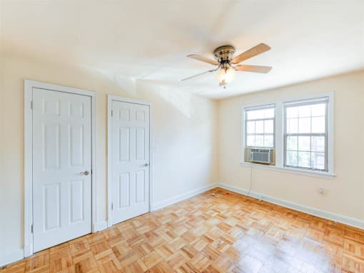 vacant bedroom with hardwood floors, large closets and windows at the meridian park apartments in columbia heights washington dc
