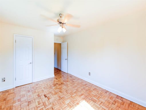 vacant bedroom with hardwood floors, closet and ceiling fan at randle circle apartments in washington dc