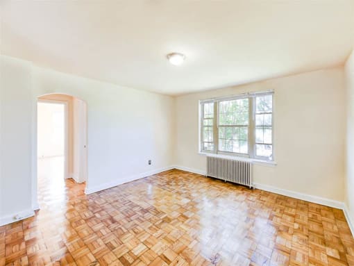 vacant living area with hardwood floors, view of bedroom and large windows at randle circle apartments in washington dc