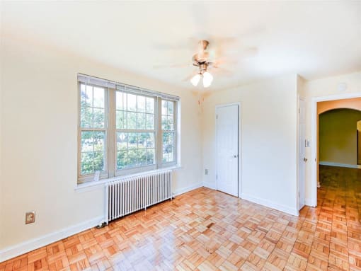 vacant bedroom with hardwood floors, closet and ceiling fan at randle circle apartments in washington dc