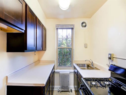 kitchen with espresso cabinets, gas range and window at randle circle apartments in washington dc