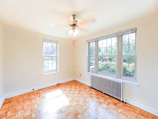 vacant bedroom with hardwood floors, closet and ceiling fan at randle circle apartments in washington dc
