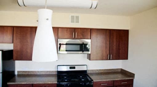 kitchen with espresso cabinetry, stainless steel appliances, and breakfast bar at sheridan station apartments in washington dc