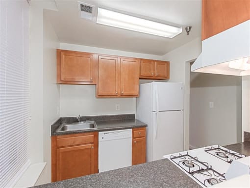 kitchen with refrigerator, dishwasher, gas range and wood cabinetry at the whitelaw apartments in washington dc
