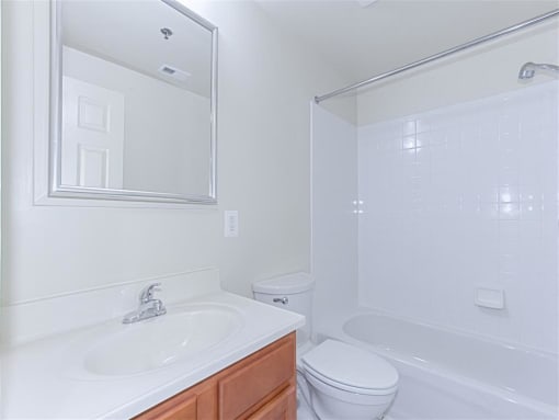 bathroom with tub, toilet, sink, mirror and cabinet at the whitelaw apartments in washington dc