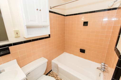 bathroom with tub, toilet, medicine cabinet and tile details at dupont apartments in washington dc
