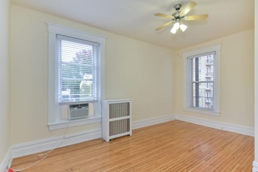 vacant bedroom with hardwood flooring, large windows, and ceiling fan at dupont apartments in washington dc