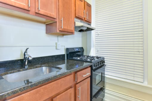 kitchen with granite countertops, tile backsplash and large windows at dupont apartments in washington dc