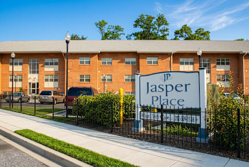 A building with a sign that says "Jasper Place" in front of it.